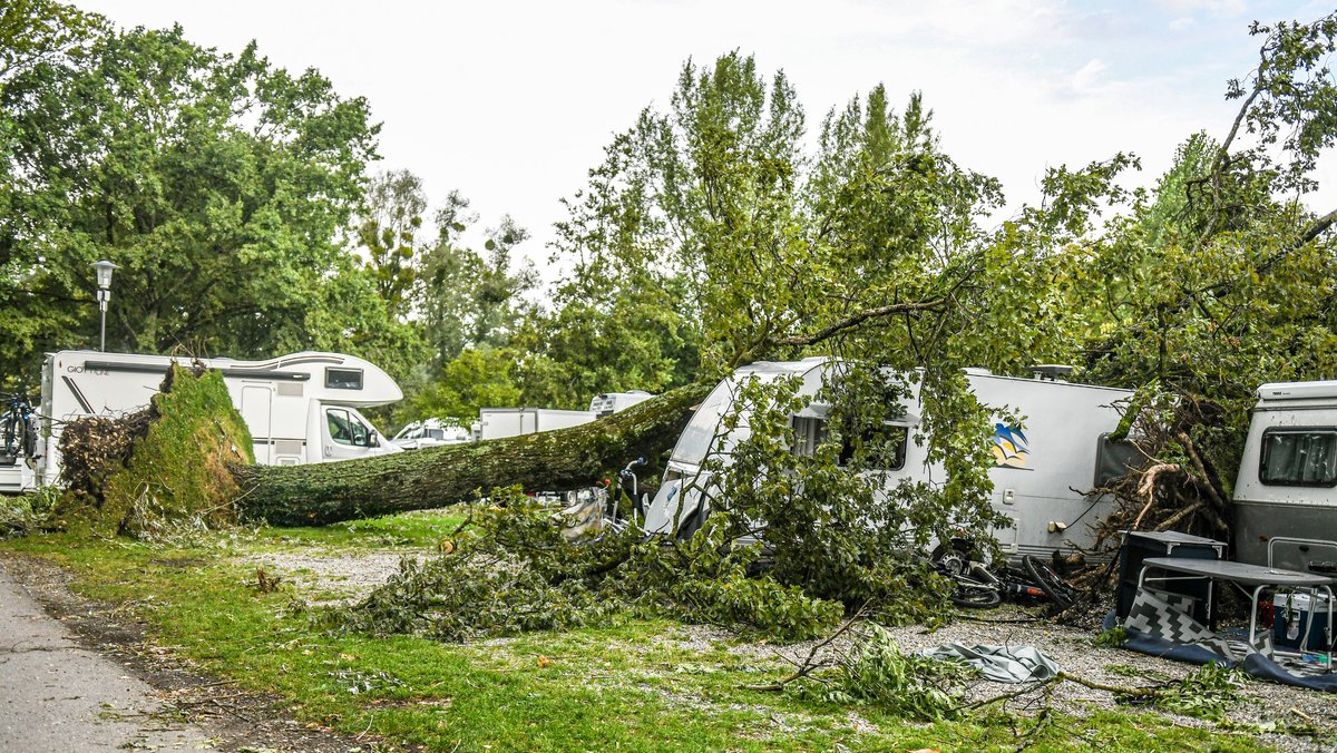 Bäume liegen nach einem Unwetter auf Campingwagen auf einem Campingplatz in Lindau am Bodensee.