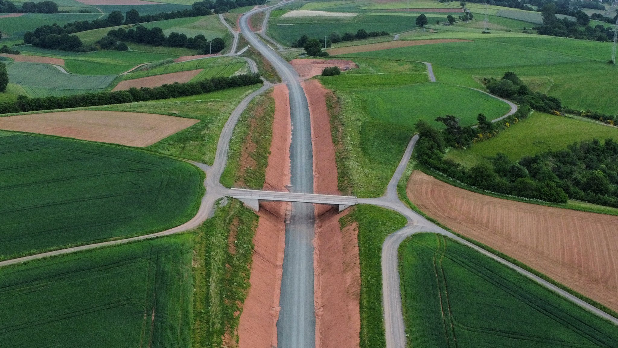 Luftaufnahme einer neu gebauten Ortsumfahrung, links und rechts davon grüne Felder. (Symbolbild)