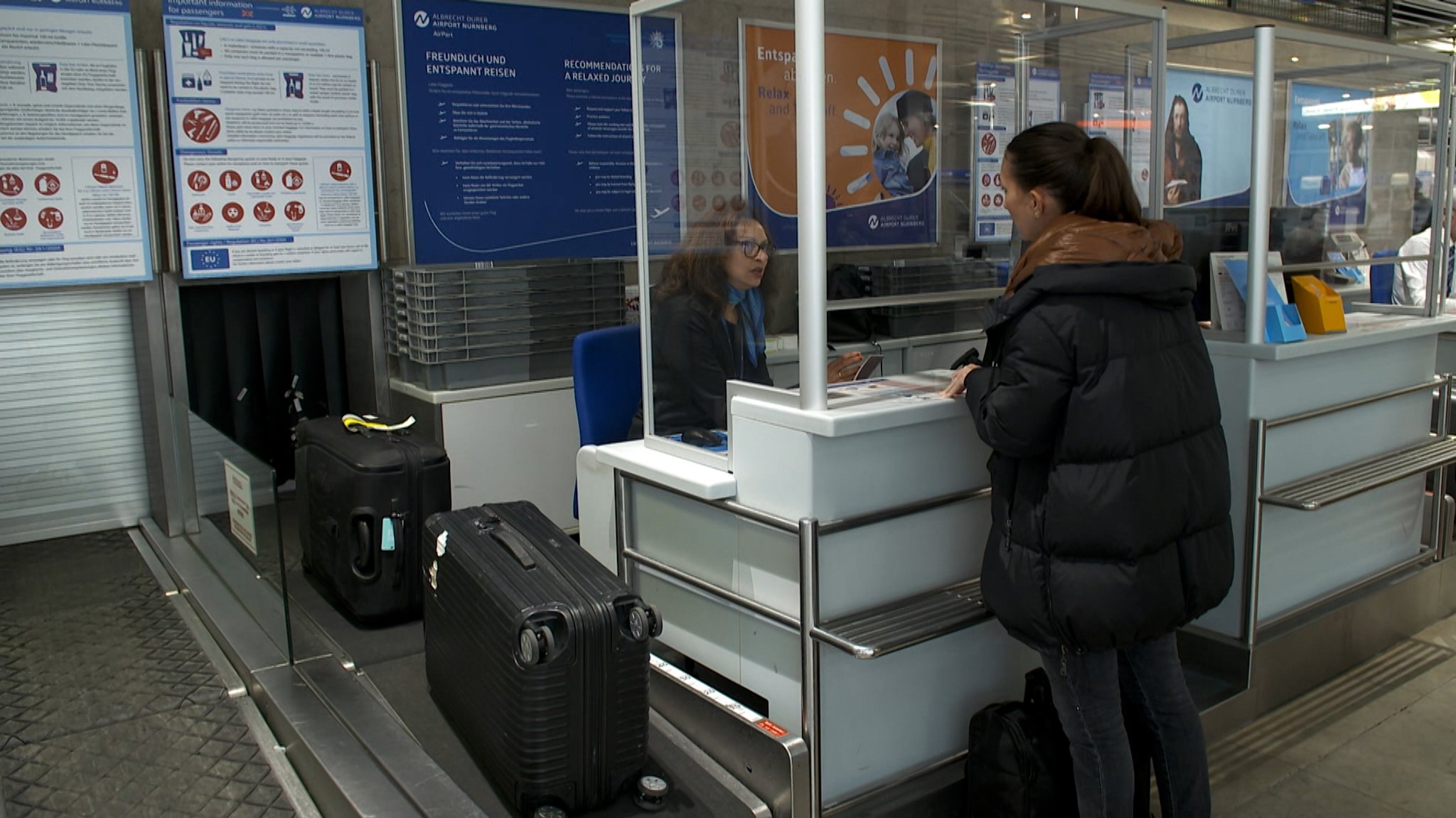 Eine Urlauberin gibt am Flughafen Nürnberg ihren Koffer auf.