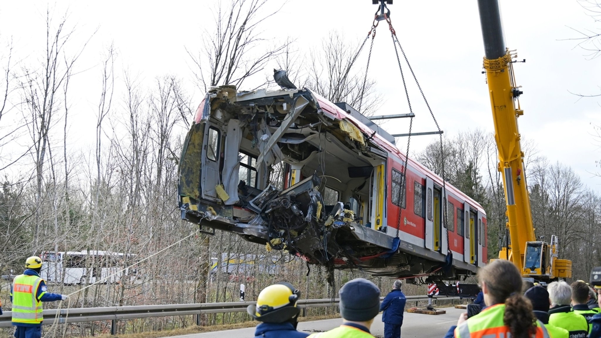 19.02.2022, Bayern, Schäftlarn: Einer der beiden jeweils rund 21 Tonnen schweren Triebwagen der verunglückten S-Bahn Züge wird auf der Bundestrasse 11 auf einen Tiefbettaufleger gehoben. Beim Zusammenstoß der beiden S-Bahnen südlich von München kam am 14. Februar ein Fahrgast ums Leben, 18 Menschen wurden verletzt. 