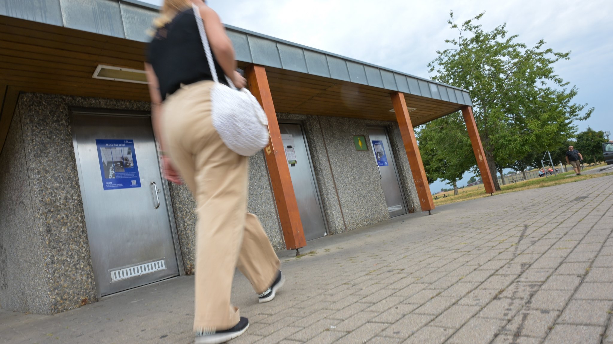 Eine Frau läuft am Parkplatz Engelberg in Gerlingen an den Toilettenanlagen vorbei. | Bild: picture alliance/dpa | Marius Bulling Eine Frau läuft am Parkplatz Engelberg in Gerlingen an den Toilettenanlagen vorbei.