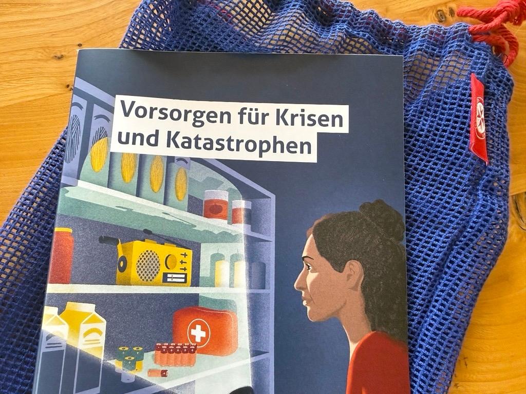 In einem blauen Säckchen teilen die Johanniter u.a. Infobroschüren, ein Dreieckstuch, Block und Stift aus