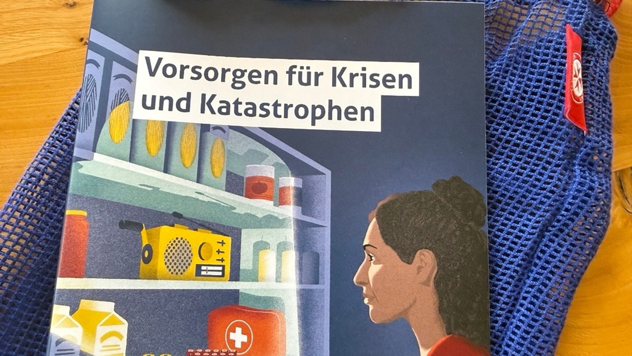 In einem blauen Säckchen teilen die Johanniter u.a. Infobroschüren, ein Dreieckstuch, Block und Stift aus