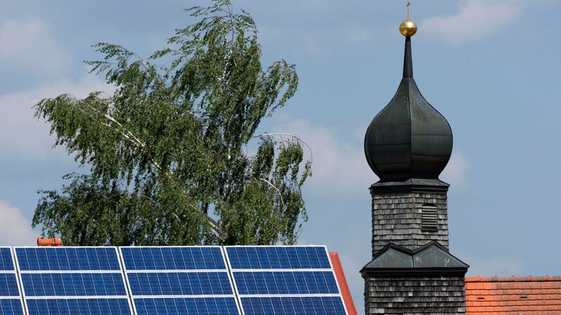 (Archiv- und Symbolbild) Photovoltaikanlage auf einem Dach, daneben eine Kirche (Archiv- und Symbolbild) | Bild: picture alliance / imageBROKER|Raimund Kutter (Archiv- und Symbolbild) Photovoltaikanlage auf einem Dach, daneben eine Kirche (Archiv- und Symbolbild)