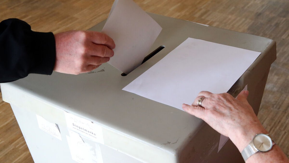 Eine Wählerin wirft ihren Wahlschein in einem Wahllokal in die Urne. 