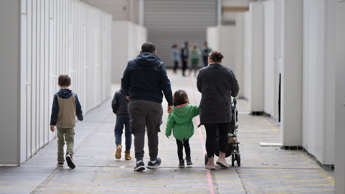 Eine Flüchtlingsfamilie geht durch eine Massenunterkunft