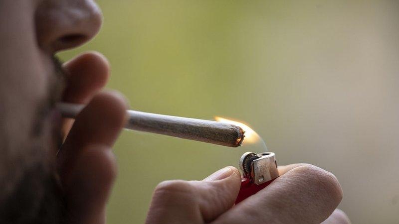Mann zündet sich einen Joint an (Symbolbild)