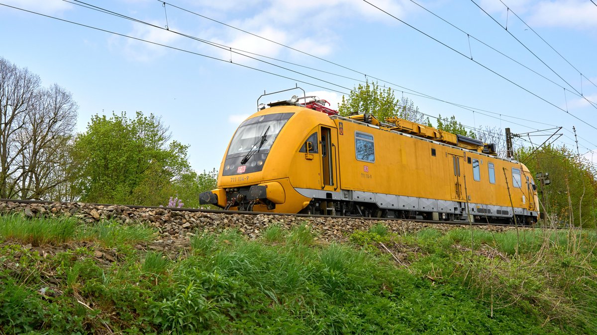 Ein gelber Wartungs - und Gleismesszug der DB Deutschen Bahn während der Fahrt.