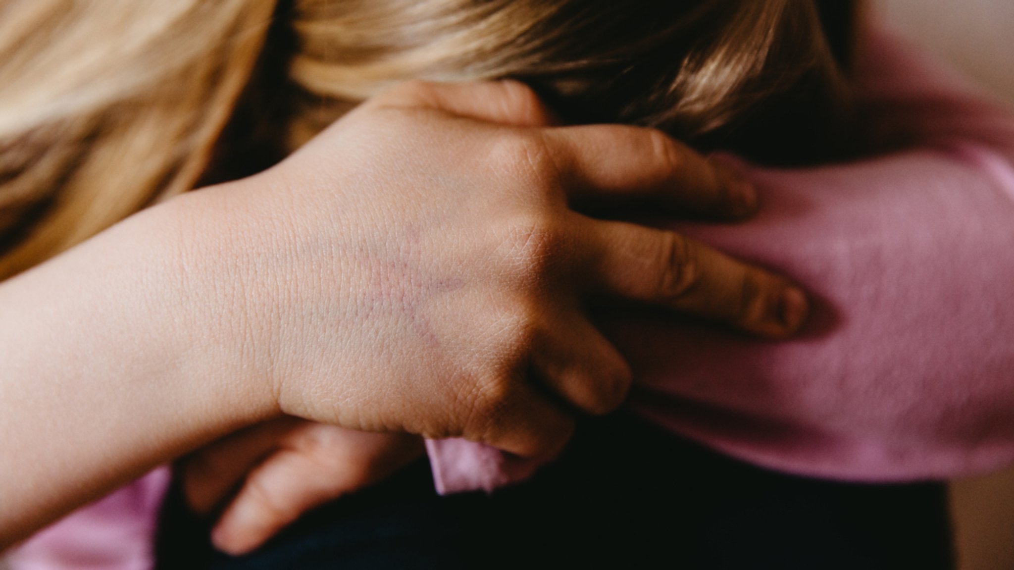 Ein Kind sitzt zusammengesunken und weint (Symbolfoto)