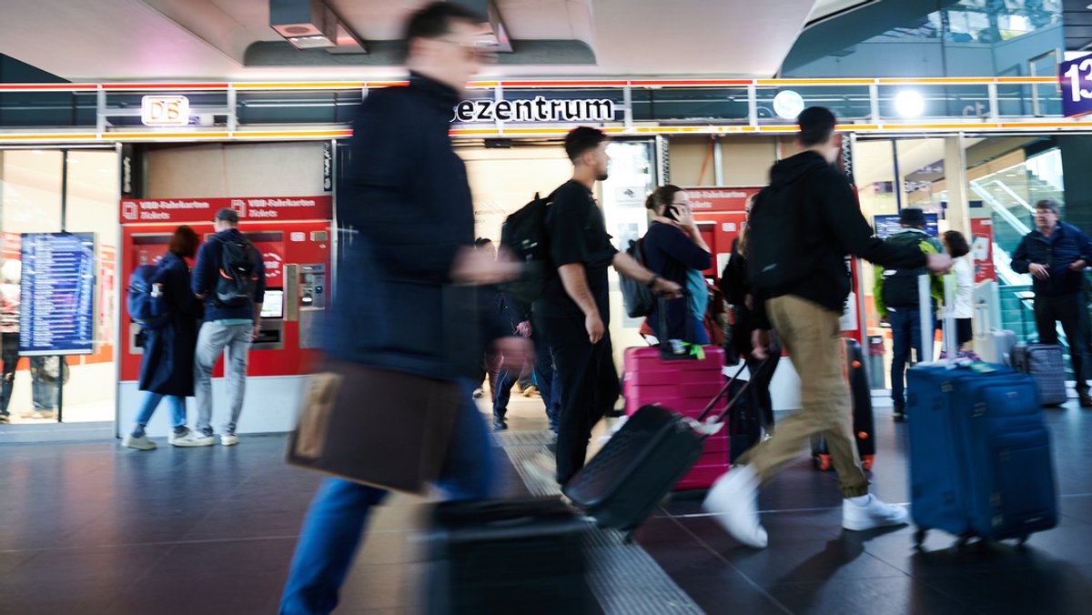 Reisende sind nach dem Warnstreik mit Koffern an einem Bahnhof unterwegs 