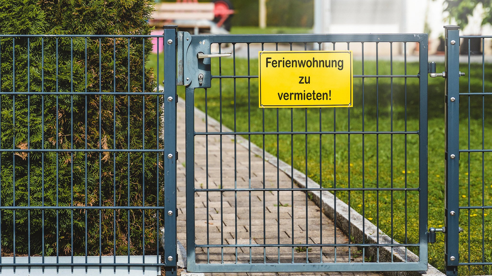 Ein Gartenzaun mit einem Schild und der Aufschrift: "Ferienwohnung zu vermieten!"