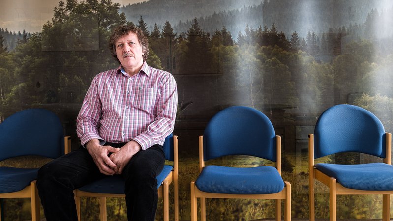 Helmut Knaus sitzt auf einem Stuhl, hinter ihm eine Wald-Tapete. | Bild: pa/SZ Photo | Sebastian Beck Helmut Knaus sitzt auf einem Stuhl, hinter ihm eine Wald-Tapete.