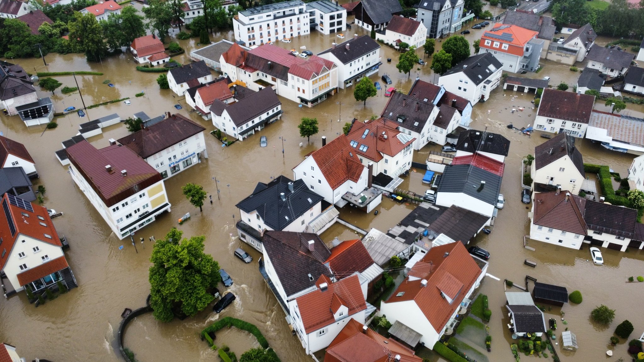 Viele Straßen sind in Babenhausen im bayerisch-schwäbischen Landkreis Unterallgäu überflutet (Aufnahme mit einer Drohne). Das Wasser läuft in die Keller der Häuser.