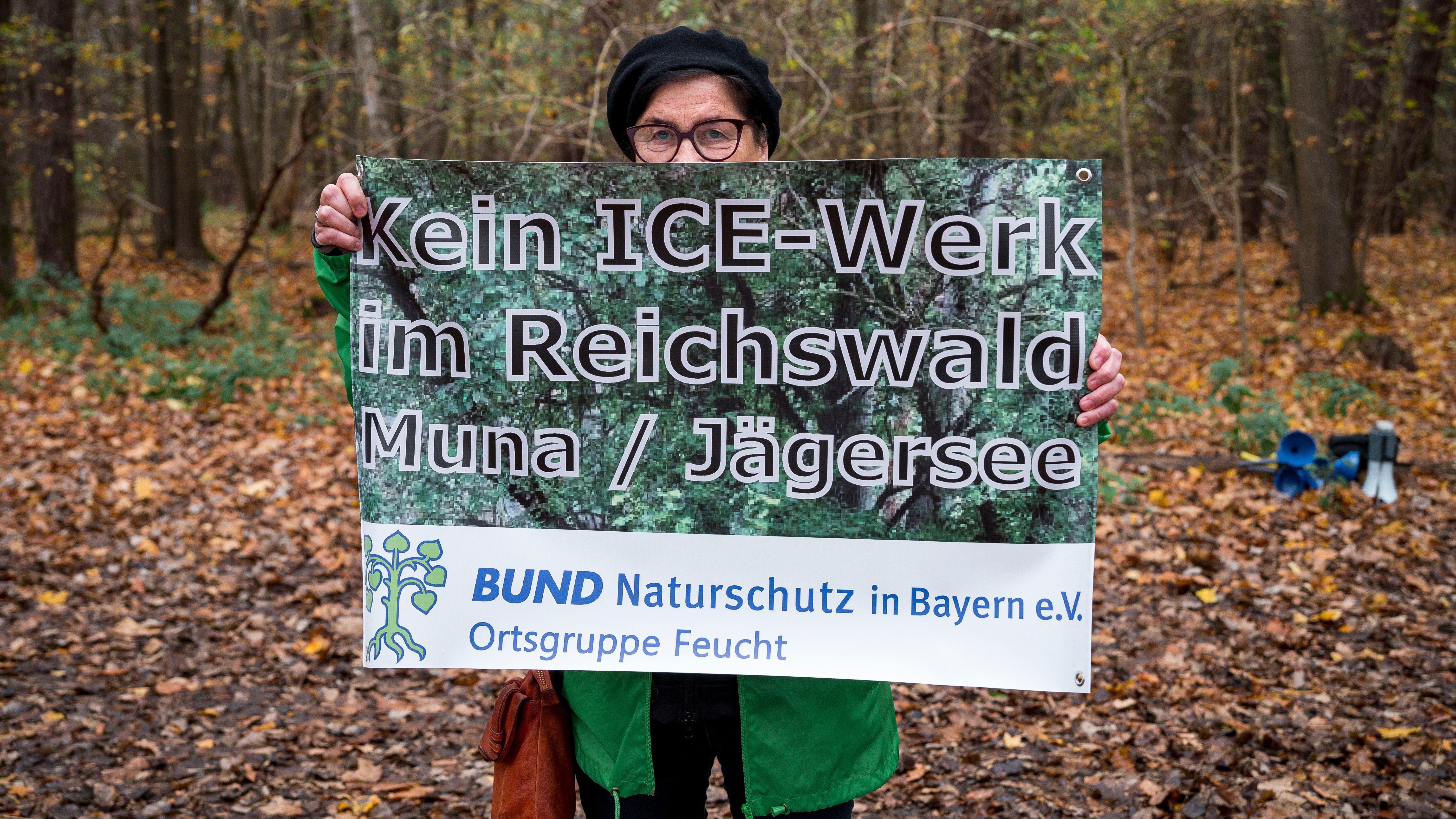 Eine Demonstrantin hält ein Plakat gegen das ICE-Werk im Reichswald in den Händen