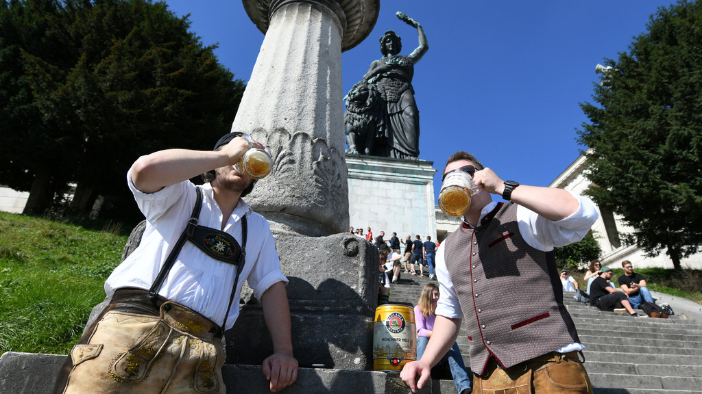Wiesnfans trinken um Punkt 12 Uhr ihre Maß unter der Bavaria