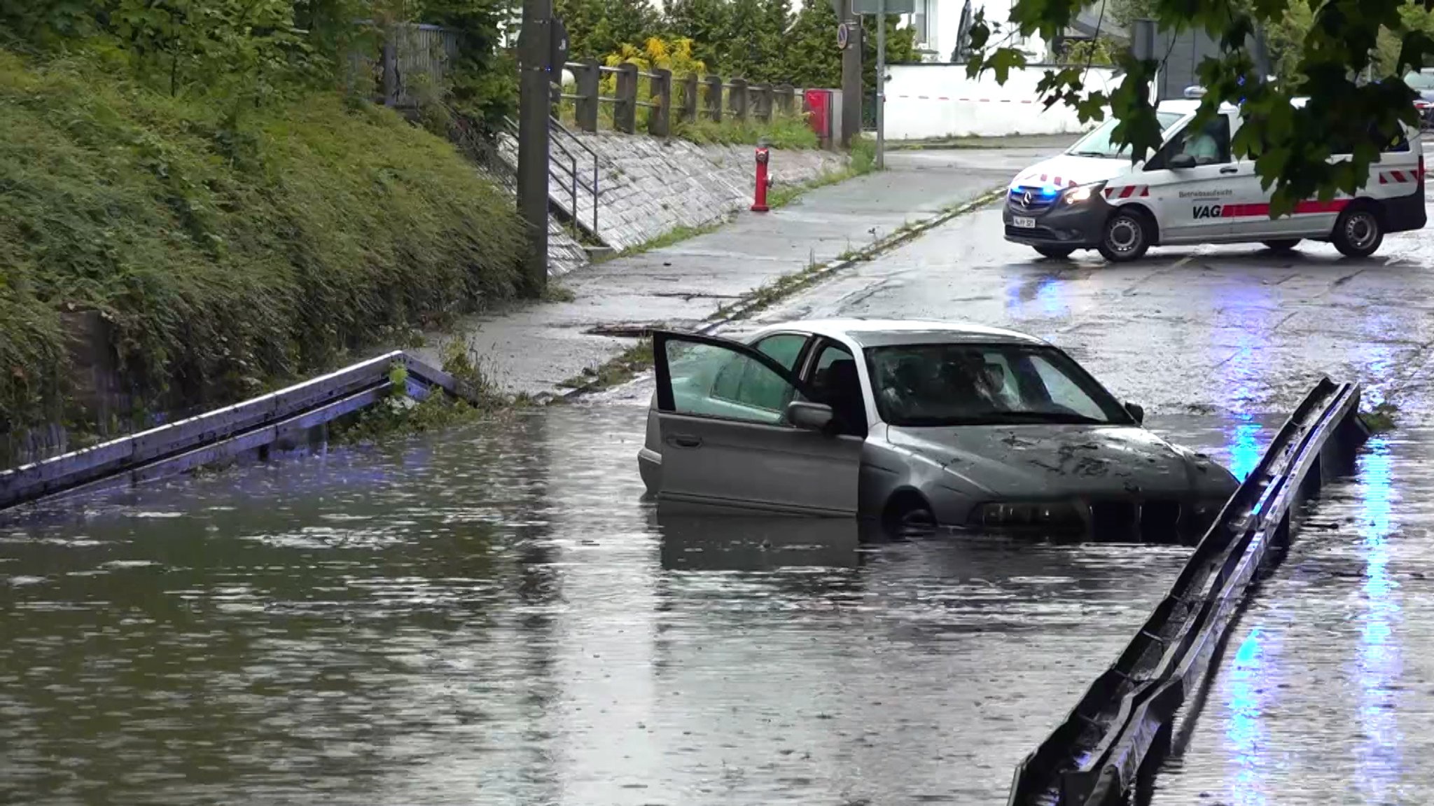 Die vollgelaufene Unterführung in Nürnberg mit einem Auto mittendrin.