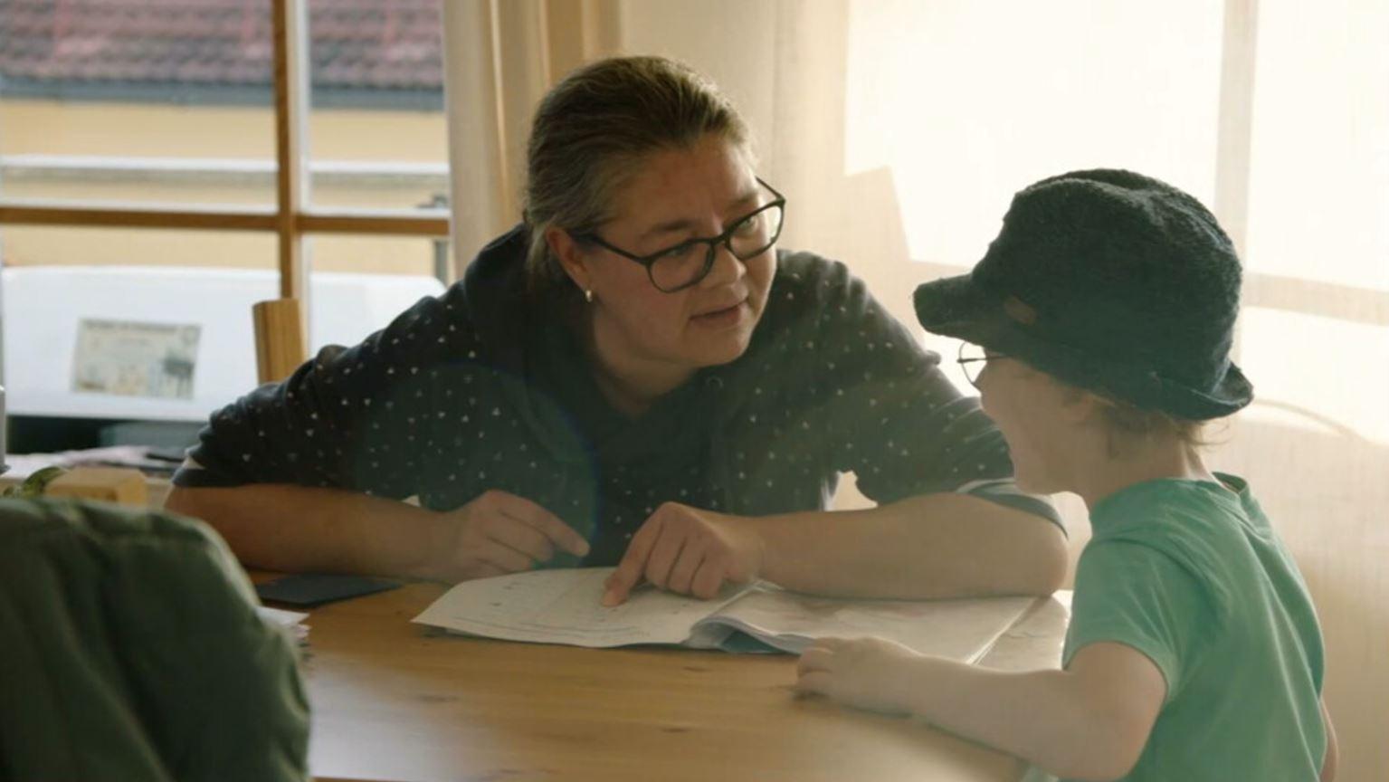Die Mutter Verena Eder sitzt mit ihrem Sohn am Küchentisch.