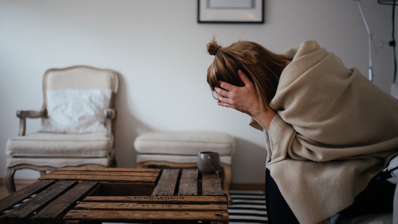 Frau sitzt im Wohnzimmer und stützt den Kopf in die Hände | Bild: BR/Julia Müller Frau sitzt im Wohnzimmer und stützt den Kopf in die Hände