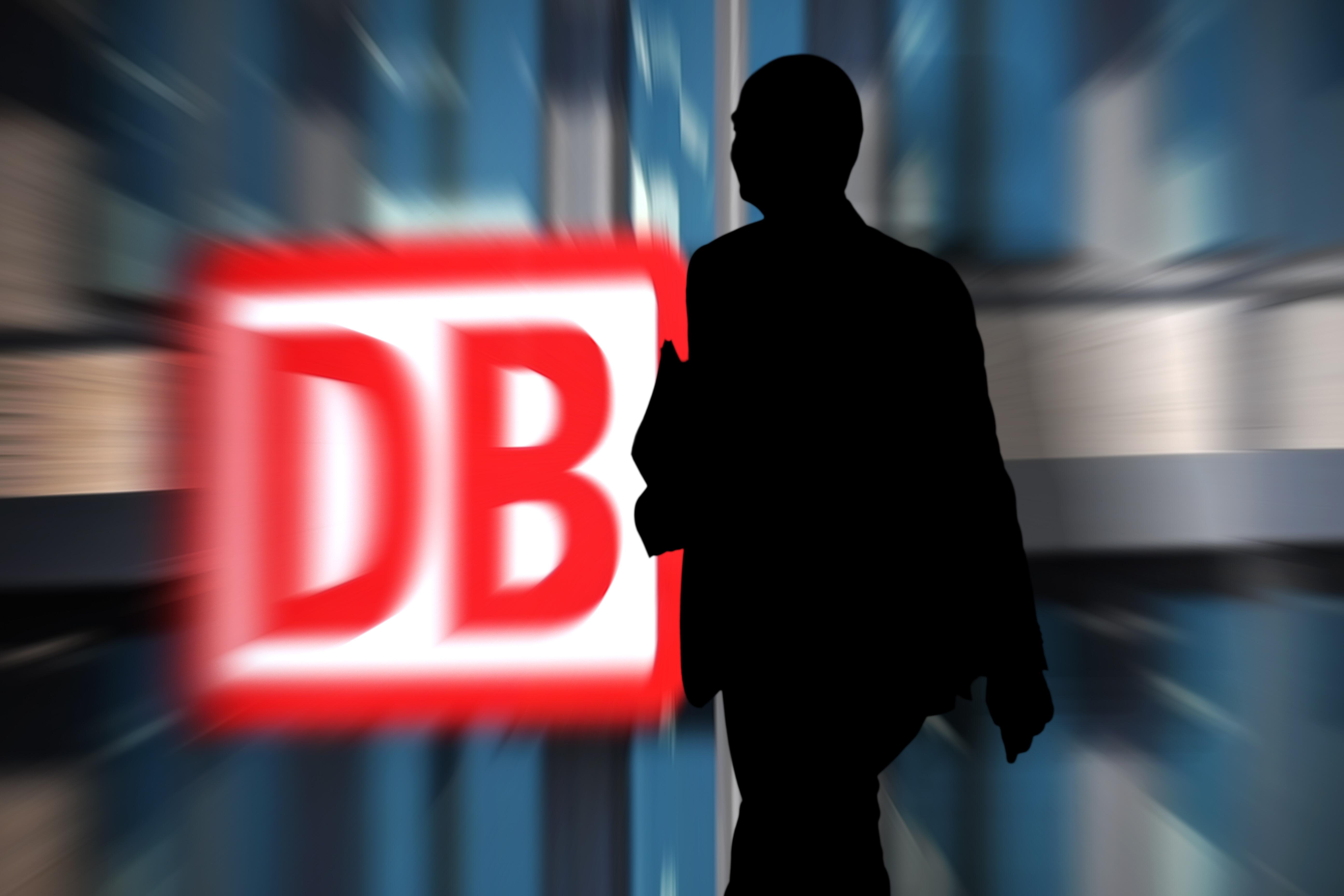 Fotomontage: Ein DB-Schild, vor dem ein Mann im Schatten geht.