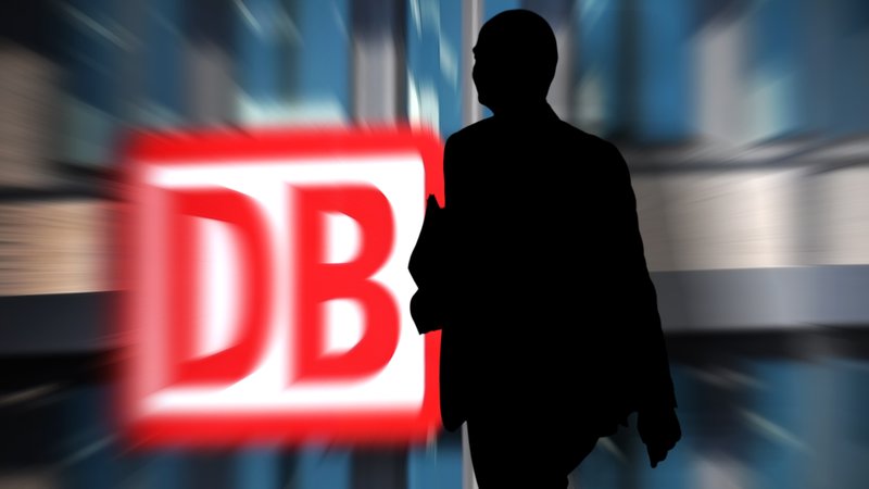 Fotomontage: Ein DB-Schild, vor dem ein Mann im Schatten geht. | Bild: picture alliance / SvenSimon | Frank Hoermann / SVEN SIMON Fotomontage: Ein DB-Schild, vor dem ein Mann im Schatten geht.