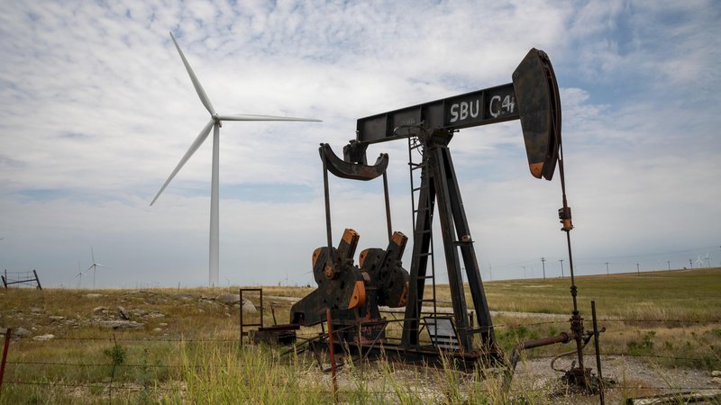 Eine Ölquelle vor Windturbinen in Oklahoma, USA. | Bild: picture alliance / imageBROKER | Jim West Eine Ölquelle vor Windturbinen in Oklahoma, USA.