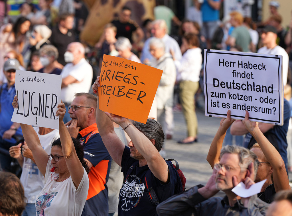 Demonstranten halten während eines Auftritts von Wirtschaftsminister Habeck in Bayreuth Plakate mit Aufschriften wie "Lügner" und Kriegstreiber"