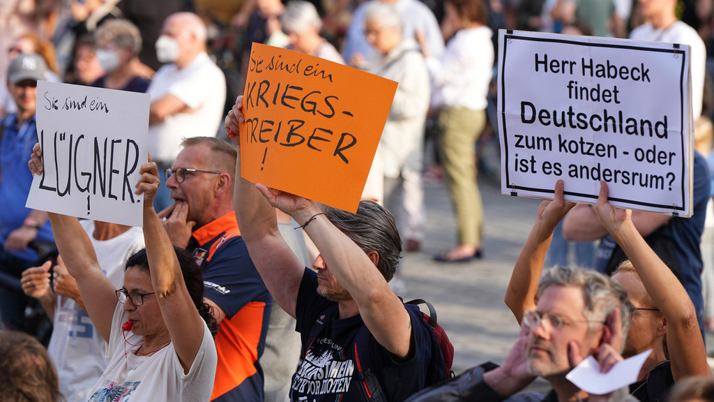 Demonstranten halten während eines Auftritts von Wirtschaftsminister Habeck in Bayreuth Plakate mit Aufschriften wie "Lügner" und Kriegstreiber"