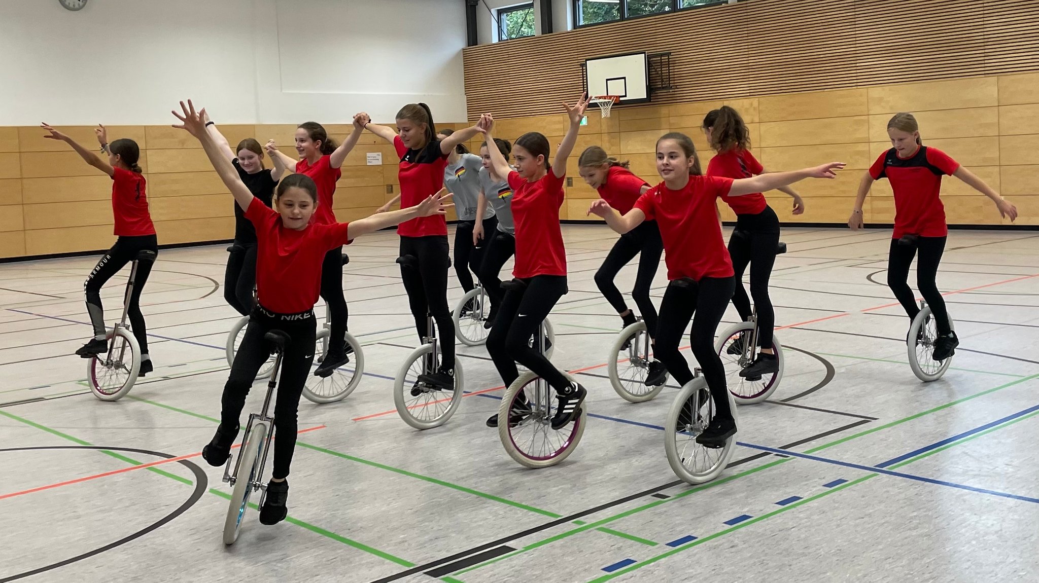 Einradfahrerinnen in einer Turnhalle.