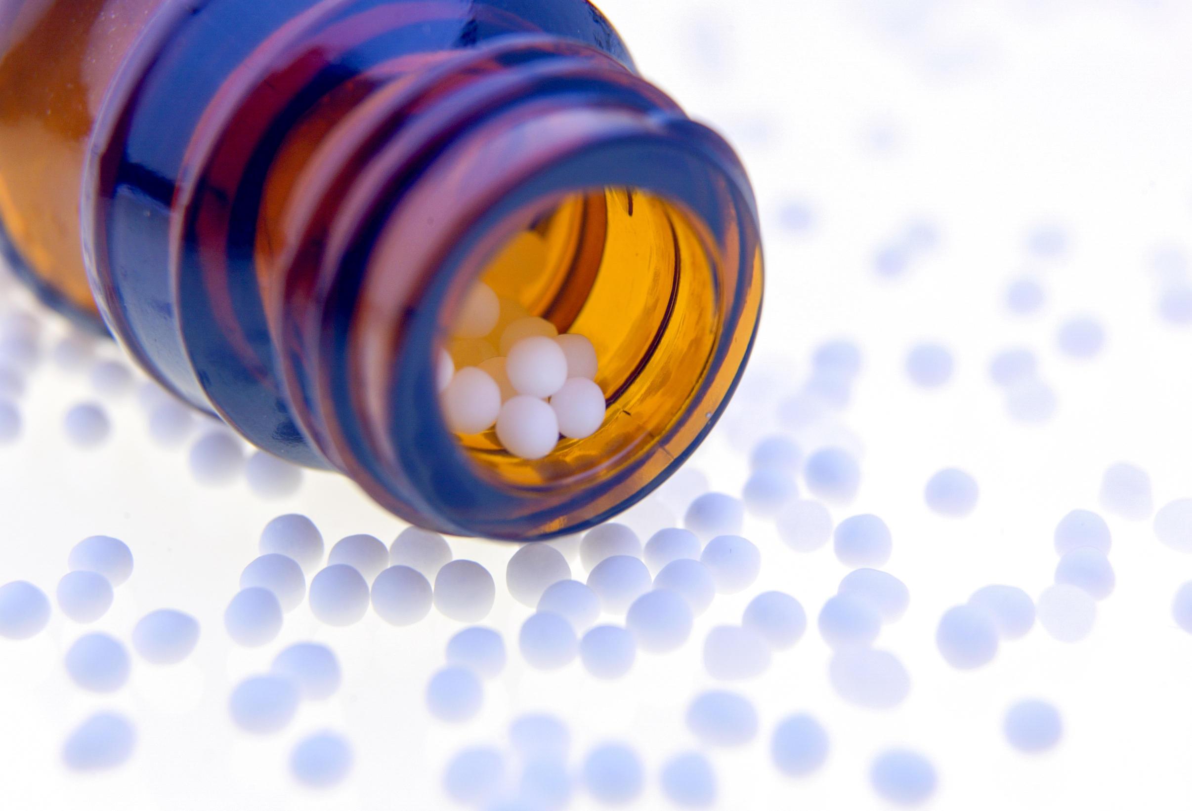 Gekippte Flasche mit Globuli.