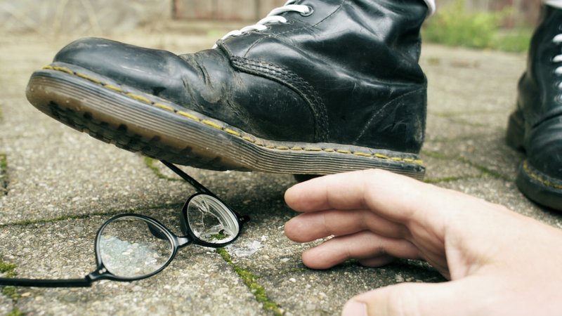 Eine Person mit in der rechten Szene verbreiteten Springerstiefeln tritt auf eine Brille, die am Boden liegt. | Bild: picture alliance / photothek | Ute Grabowsky Eine Person mit in der rechten Szene verbreiteten Springerstiefeln tritt auf eine Brille, die am Boden liegt.