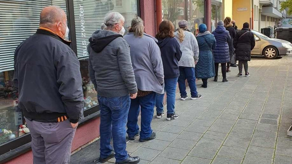 Lange Menschenschlange vor einem Gebrauchtwarenladen der Stadtmission in Nürnberg