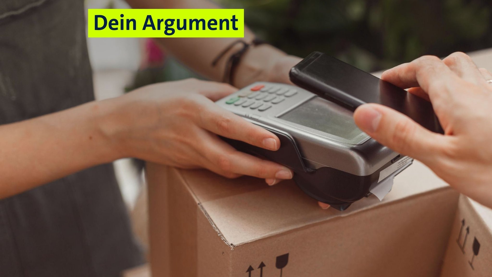 Zwei Hände halten ein EC-Lesegerät über einem Paket. Eine andere Hand im Bild hält ihr Handy zum Bezahlen auf das Lesegerät. Oben am Bildrand steht der Schriftzug "Dein Argument". 