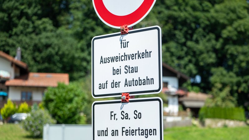 An einer Straße in Frasdorf steht ein Schild mit der Aufschrift "für Ausweichverkehr bei Stau der Autobahn - Fr, Sa, So und an Feiertagen". Wer bei Stau auf der Autobahn auf Landstraßen ausweicht, muss im Landkreis Rosenheim mit einem Bußgeld rechnen. | Bild: dpa-Bildfunk/Leonie Asendorf An einer Straße in Frasdorf steht ein Schild mit der Aufschrift "für Ausweichverkehr bei Stau der Autobahn - Fr, Sa, So und an Feiertagen". Wer bei Stau auf der Autobahn auf Landstraßen ausweicht, muss im Landkreis Rosenheim mit einem Bußgeld rechnen.
