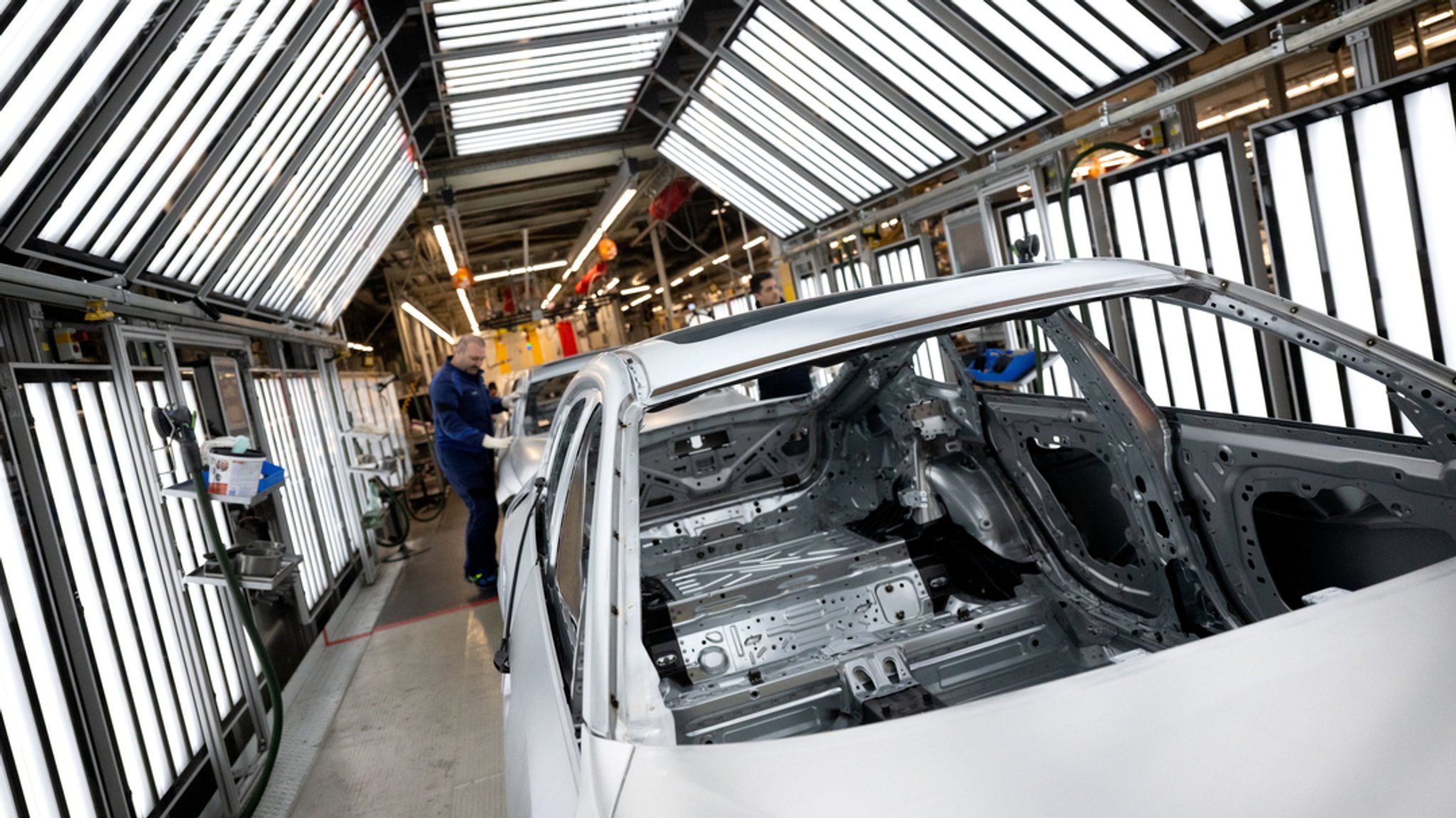 Mitarbeiter arbeiten in einem Werk in der Produktion an der Karosserie von Autos. (SYMBOLBILD)