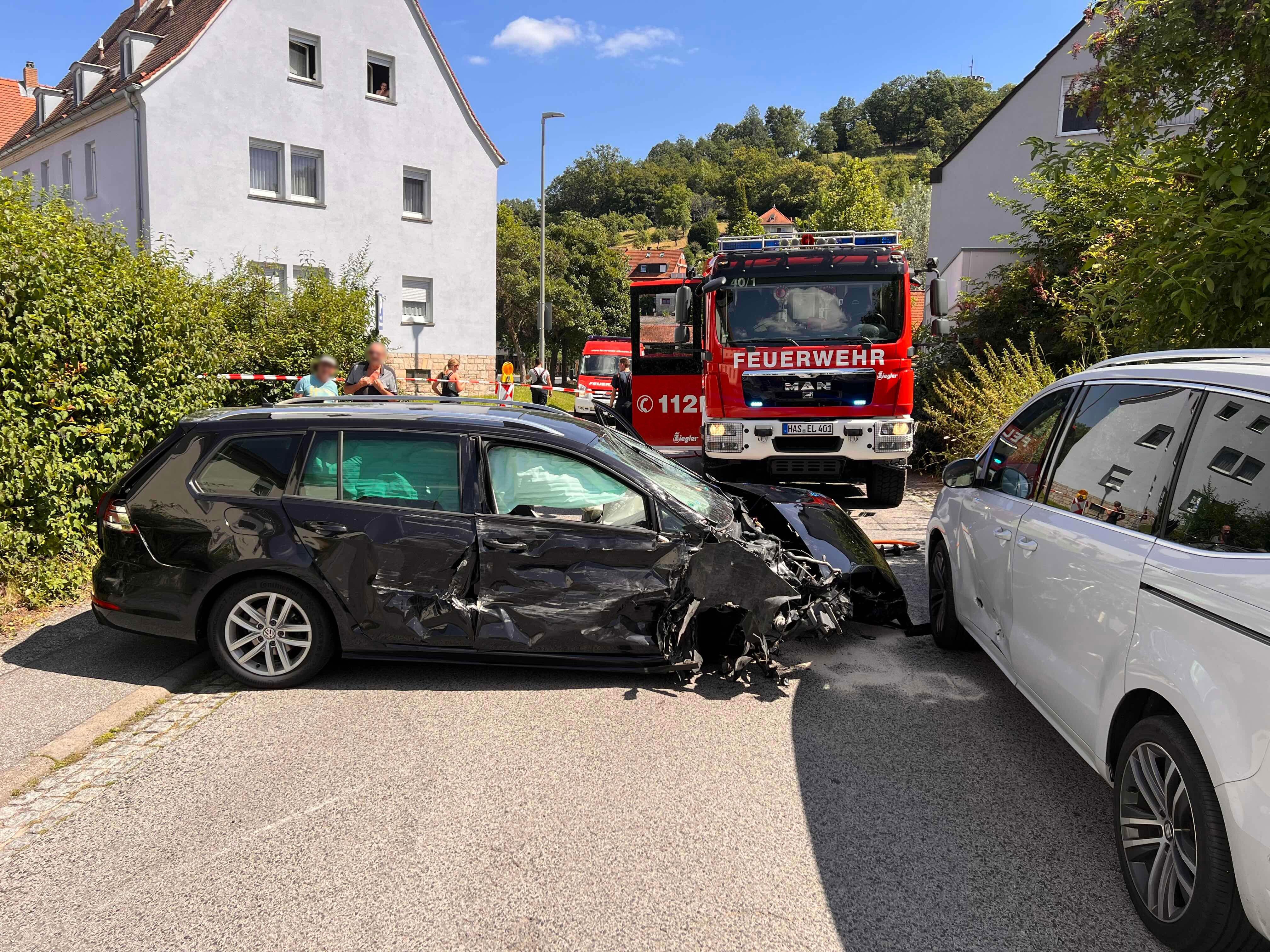 14-Jähriger kollidiert mit sieben Autos in Eltmanner Wohngebiet: Zu sehen ist das demolierte Auto und die Einsatzkräfte im Hintergrund.