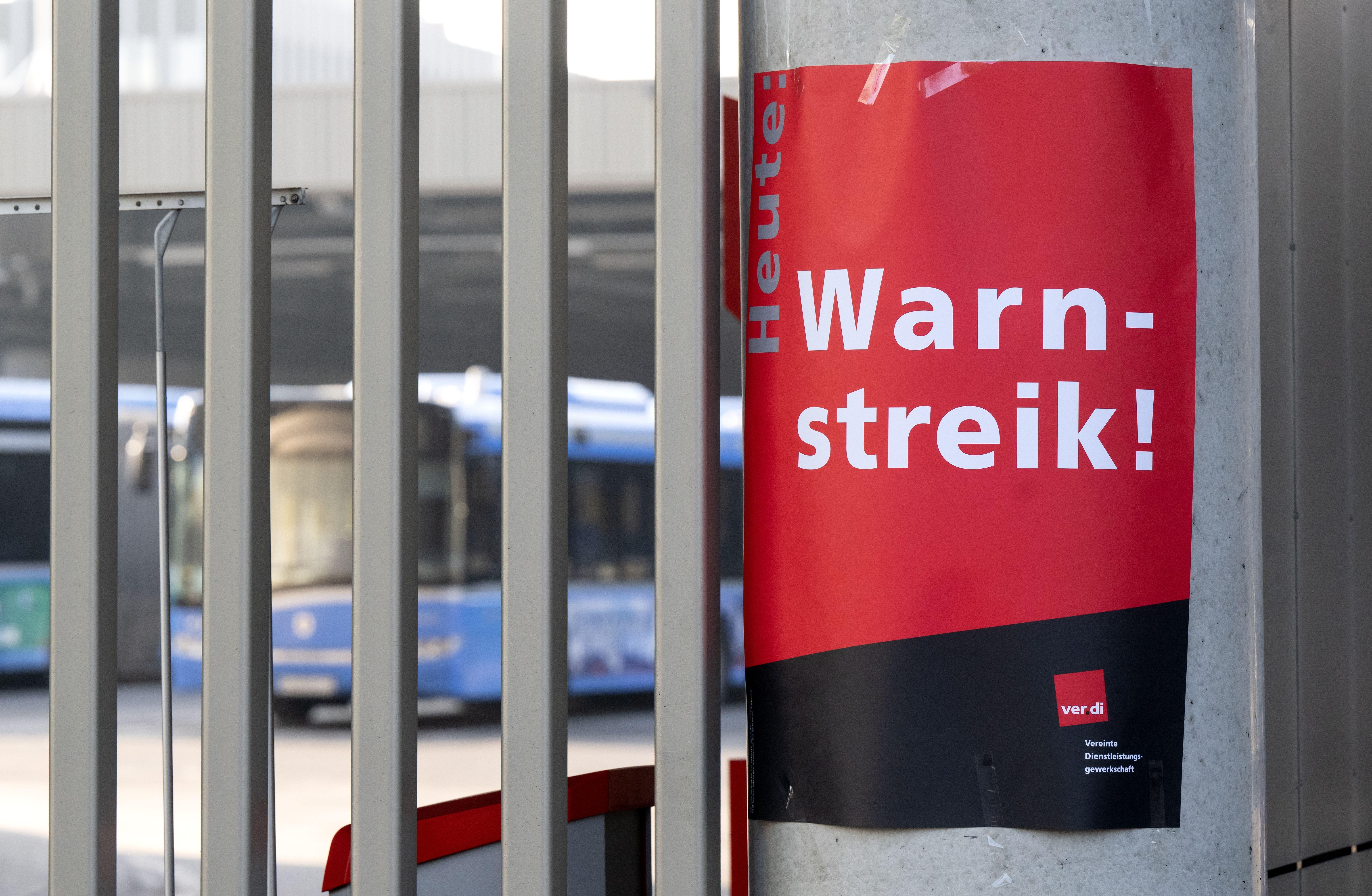 Ein Zettel mit der Aufschrift "Heute Warnstreik!" ist an der Zufahrt von einem Busdepot in München zu sehen.