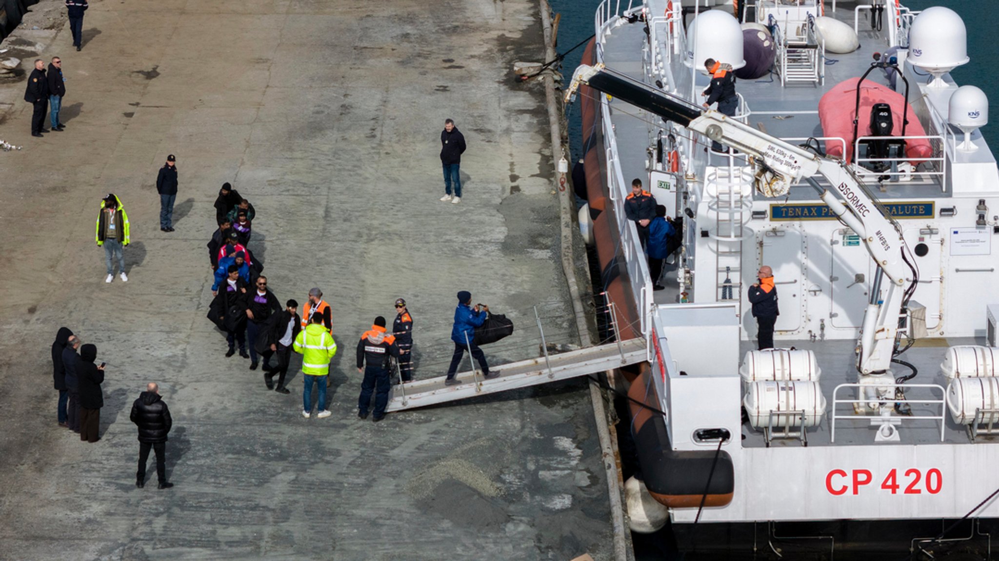 (Symbolbild) Migranten besteigen im Hafen von Shengjin im Nordwesten Albaniens ein Schiff der italienischen Küstenwache. Laut Bundesinnenministerium wäre eine Auslagerung von Asylverfahren in Drittstaaten möglich, wenn auch aufwändig. 