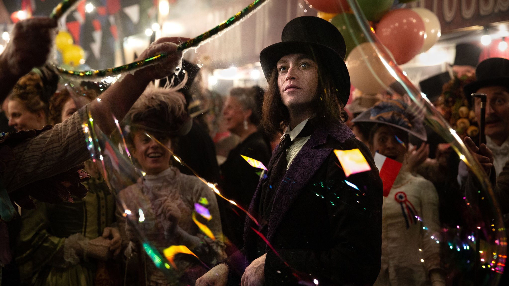 Caleb Landry Jones als Dracula, er trägt Frack und Zylinder, um ihn herum wird gefeiert | Bild: Shanna Besson © 2025 LBP - Europacorp - TF1 Films Production - SND/ Leonine Studios Caleb Landry Jones als Dracula, er trägt Frack und Zylinder, um ihn herum wird gefeiert