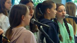 Schülerinnen singen in Mikrofone. | Bild:BR/Vera Held