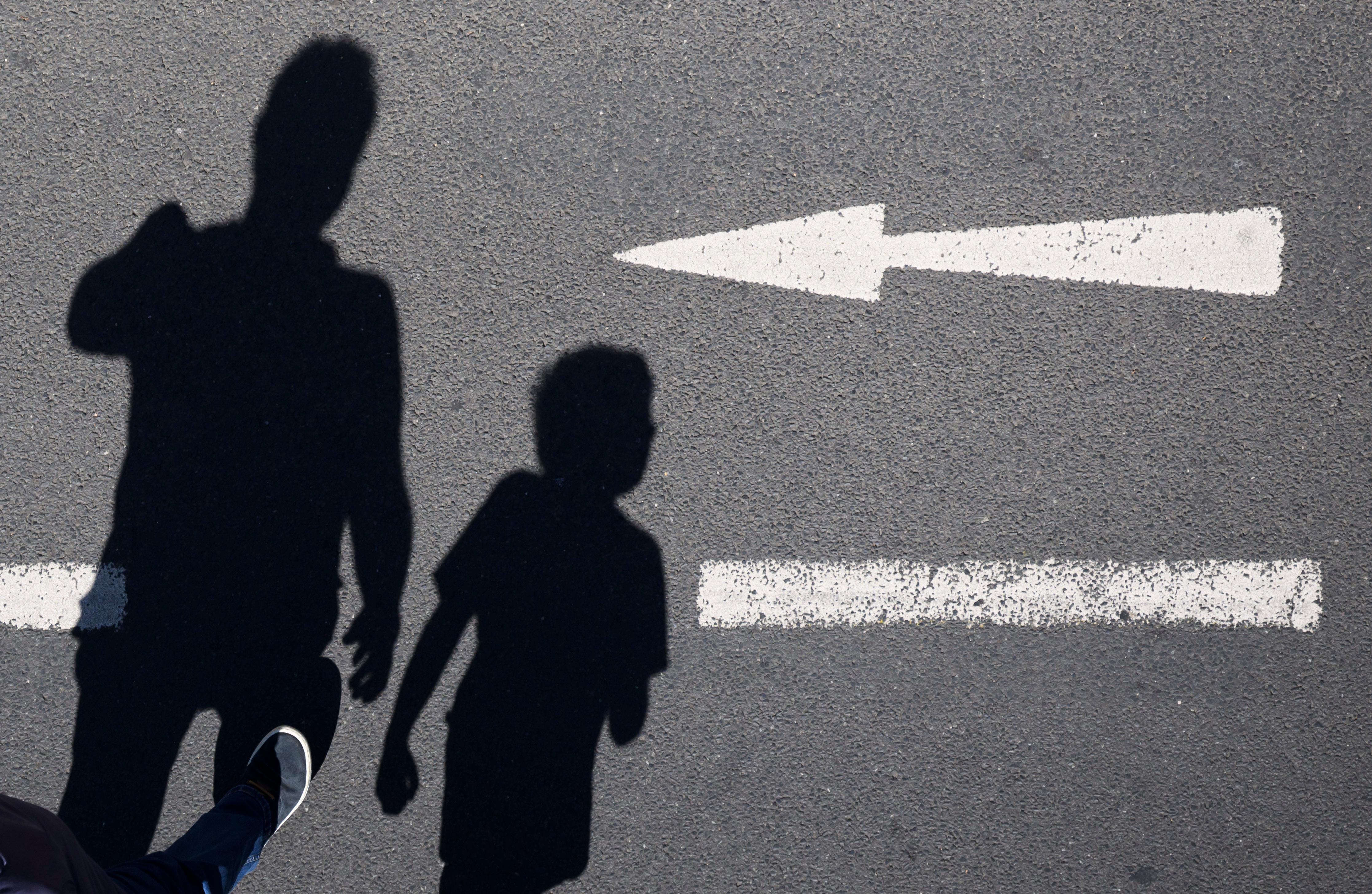 Symbolbild: Die Schatten eines Erwachsenen und eines Kindes