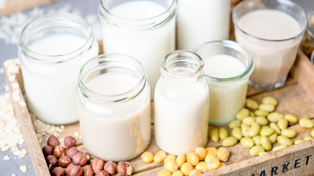 Verschiedne Gläser mit Ersatz-Milch auf einem Tablett und verschiedene Zutaten wie Mandeln, Nüsse, Erbsen. | Bild: picture alliance / dpa Themendienst | Zacharie Scheuer Verschiedne Gläser mit Ersatz-Milch auf einem Tablett und verschiedene Zutaten wie Mandeln, Nüsse, Erbsen.