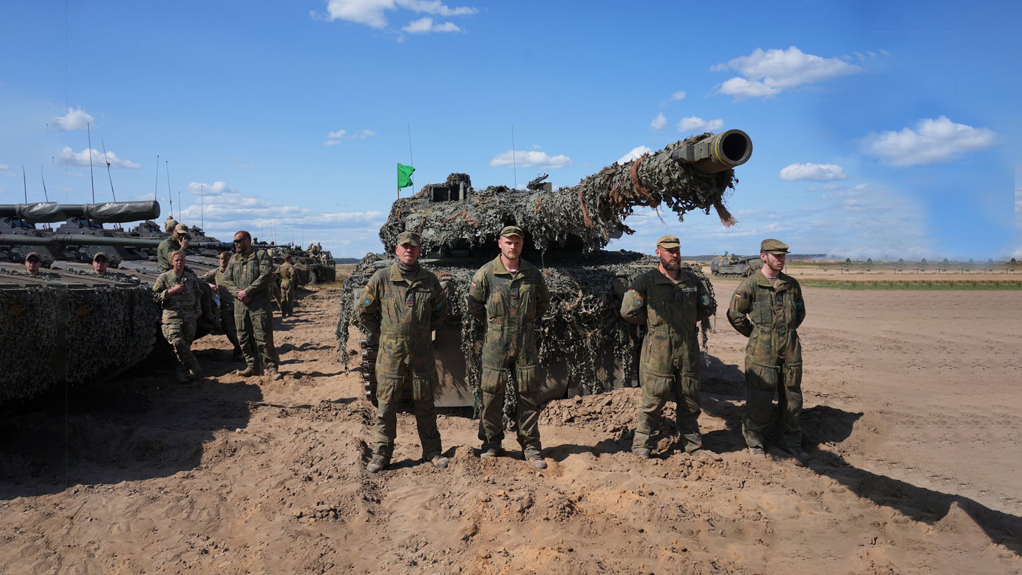 Soldaten der Bundeswehr stehen vor einem Panzer.