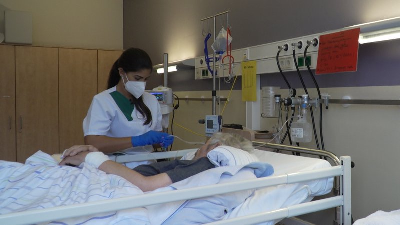 Camilla Medaglia aus Rio kümmert sich an einem Krankenhausbett um einen Patienten. 
