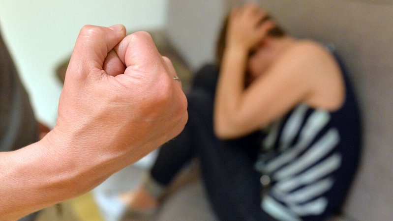 Eine Frau versucht, sich vor der Gewalt eines Mannes zu schützen (gestellte Szene). 