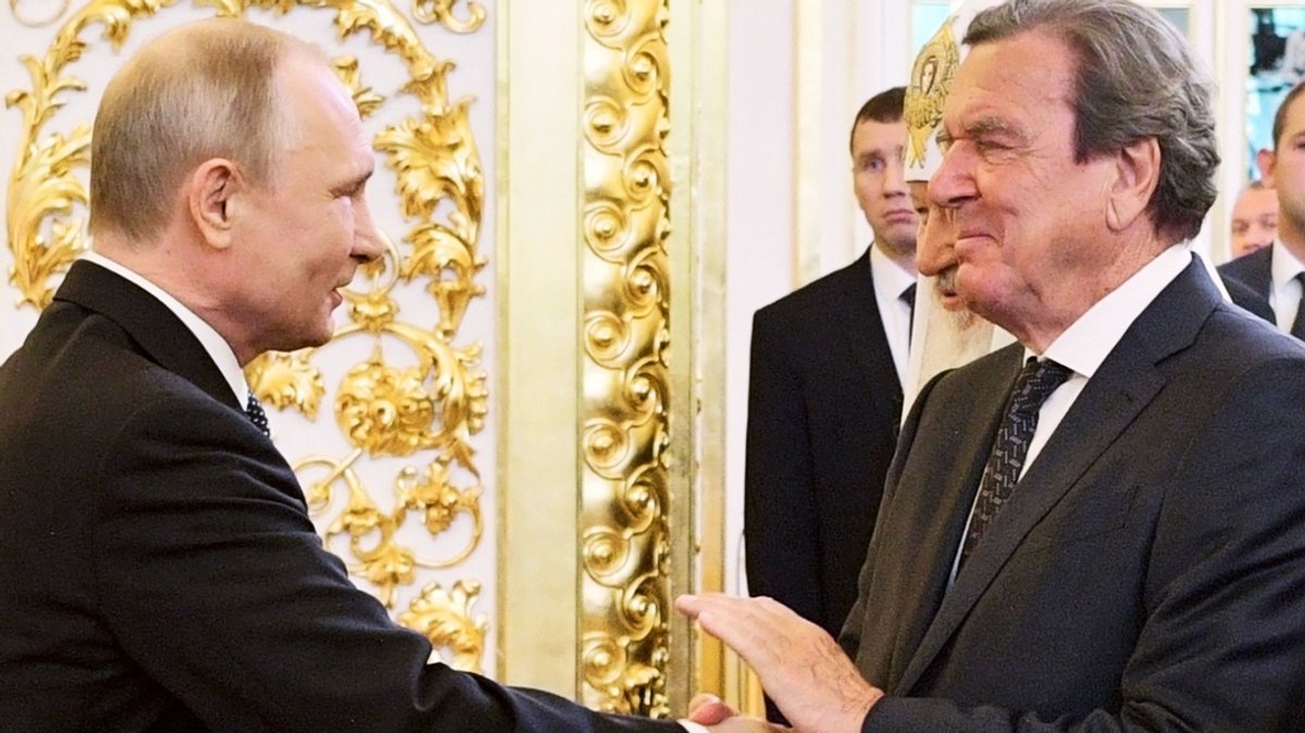 Archivbild, 07.05.2018, Russland, Moskau: Schröder (r), ehemaliger deutscher Bundeskanzler, gibt Putin (l), Präsident von Russland, die Hand.