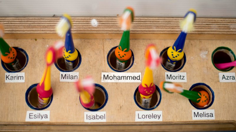 Namensschilder an einem Ständer für Zahnbürsten in einer Kita. Kinder, die mehrsprachig aufwachsen oder zu Hause wenig Deutsch sprechen, profitieren besonders von früher Förderung in Kita und Schule. | Bild: dpa-picture alliance / IPON | Stefan Boness Namensschilder an einem Ständer für Zahnbürsten in einer Kita. Kinder, die mehrsprachig aufwachsen oder zu Hause wenig Deutsch sprechen, profitieren besonders von früher Förderung in Kita und Schule.