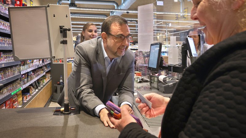 Gesundheitsminister Klaus Holetschek steht an der Supermarkt-"Ratschkasse" in Buxheim