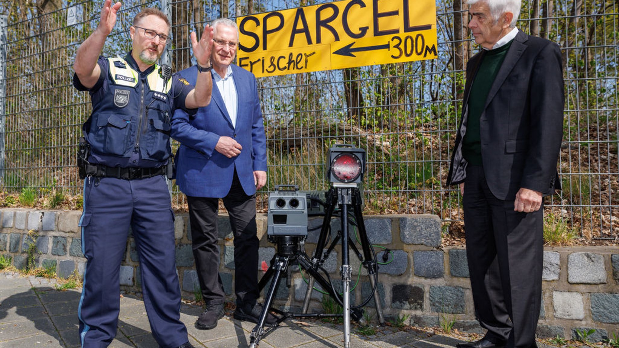 21.04.2023, Bayern, Nürnberg: Hauptkommissar Dirk Klinge (l), Sachbereichsleiter der Verkehrspolizeiinspektion Nürnberg, erläutert während des sogenannten Blitzmarathons Joachim Herrmann (M, CSU), Innenminister von Bayern, und Wolfgang Gerstberger, Stellvertretender Vorsitzender der Landesverkehrswacht Bayern, die Funktionsweise des Geschwindigkeits-Messsystems vom Typ Poliscan FM1 des Herstellers Vitronic. An rund 1800 Messstellen in ganz Bayern achten Polizei und Beschäftigte der Gemeinden sowie der kommunalen Verkehrsüberwachung auf Raserinnen und Raser. Vor allem wird aber auch dort kontrolliert, wo die Gefahr für Unfälle durch zu schnelles Fahren am größten ist oder häufig zu schnell gefahren wird. Foto: Daniel Karmann/dpa +++ dpa-Bildfunk +++