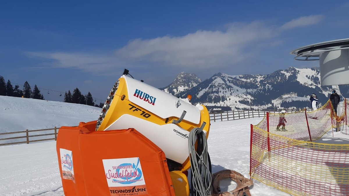 Eine Schneekanone am Skigebiet Sudelfeld mit der Aufschrift "Hubsi", benannt nach Wirtschaftsminister Hubert Aiwanger. Im Hintergrund verschneites Bergpanorama.
