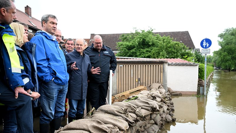 Reichertshofen, 03.06.24: Bundeskanzler Scholz und Bayerns Ministerpräsident Söder (beide mittig im Bild) hinter einer Barriere aus Sandsäcken. | Bild: pa/dpa/Sven Hoppe Reichertshofen, 03.06.24: Bundeskanzler Scholz und Bayerns Ministerpräsident Söder (beide mittig im Bild) hinter einer Barriere aus Sandsäcken.